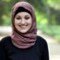 Portrait of a young smiling girl in a hijab, on nature, in a park in the background. 50 fps 4k